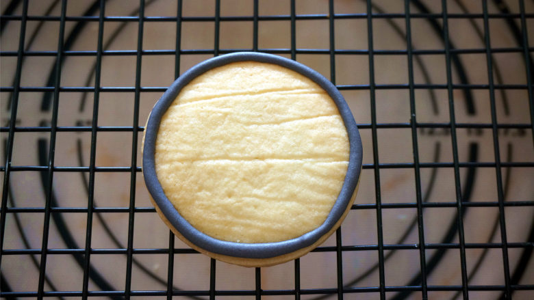 愤怒的小鸟糖霜饼干,用一个小碗,装入两大勺浓糖霜,加入食用黑色素,调成黑色糖霜,装入裱花袋,剪出一个小口,在饼干上勾边。