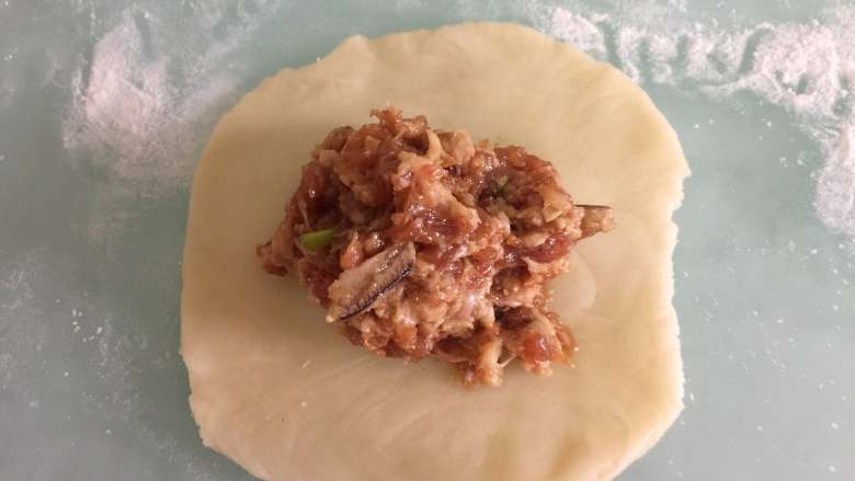 蟹粉鲜肉月饼,取一个剂子擀成圆片,放入适量蟹粉鲜肉馅