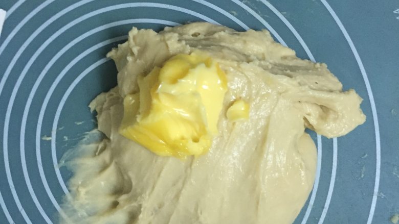 菠萝包,摔揉结合揉至面拉开有弹性,破洞边缘呈不光滑时加入黄油继续揉至扩展阶段