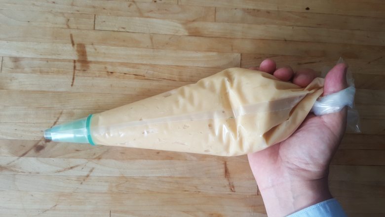 乳酪泡芙(gougères)(法语),将面团放在一端带圆形开口的袋子里。