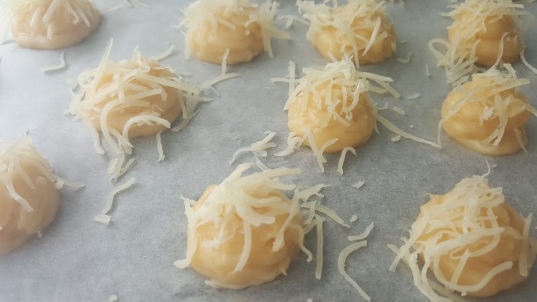 乳酪泡芙(gougères)(法语),把剩下的奶酪撒在面团上。