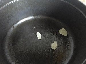 黑酱油+小筑私房卤鸭翅,鸭翅放在一边,将干净的铸铁锅用大火加热后转小火,倒入能抹匀锅底的油就够了,加入冰糖熬化,慢慢呈现褐色。