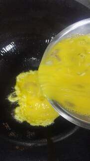 虾仁煎鸡蛋,鸡蛋打散和虾仁搅拌均匀，锅入油烧热将蛋液倒入锅中。