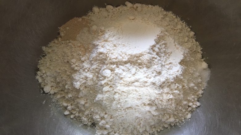 天然色素椰蓉花朵面包,将全麦面粉放入盆中,分别在两个角落加入酵母和食盐;