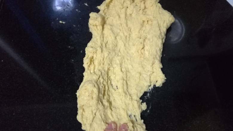 面包入门基本功之黄油面包卷,面盆上没有面渣后,把面团倒在操作台上。此时面团很湿,很粘手。用两手掌大幅度、前后不断地搓擦面团。