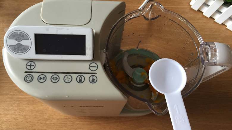 婴儿辅食之南瓜米糊,先将搅拌杯里的蒸馏水倒出到一个杯子里,再把南瓜倒进搅拌杯,加入适量蒸馏水;