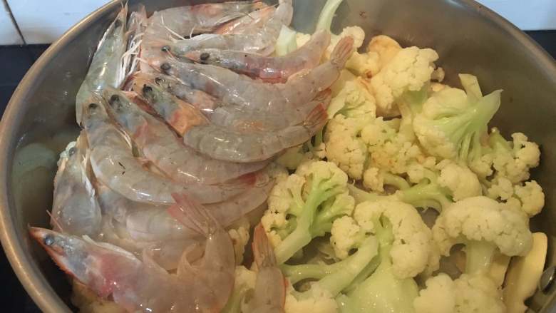 一锅出海鲜烩,焖3分钟后,开盖,在一边码上大虾。要平铺均匀。