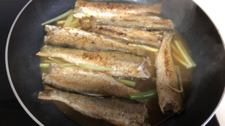 野生小鱼,小火煮一会把鱼轻轻翻个面,煮到小鱼入味即可关火