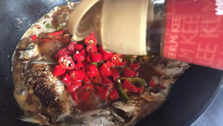 香辣鲫鱼,加入适量醋,下入蒜头,盖上盖焖煮入味