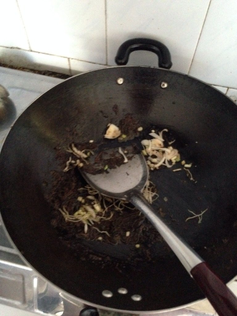 桂林油茶速成做法,倒入葱根,葱段,姜,蒜接着炒几分钟