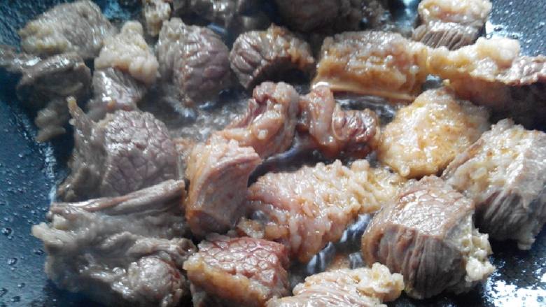 牛腩炖土豆,油开下牛腩勤快翻炒,炒至牛腩的水分干了,肥的地方有点焦黄即可。