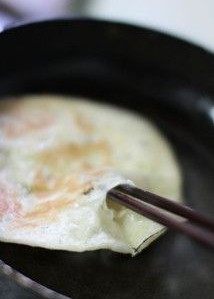 虾仁鸡蛋灌酥饼,可见饼面金黄，等饼鼓起，用筷子从边缘鼓起处挑一破洞，可以稍大些