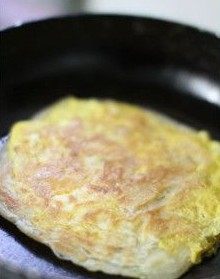 虾仁鸡蛋灌酥饼,继续用小火烙饼，烙至蛋液半凝固状，再翻面