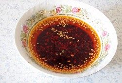 重庆小面 ,将热油浇在辣椒碗中,搅拌均匀即成油辣子