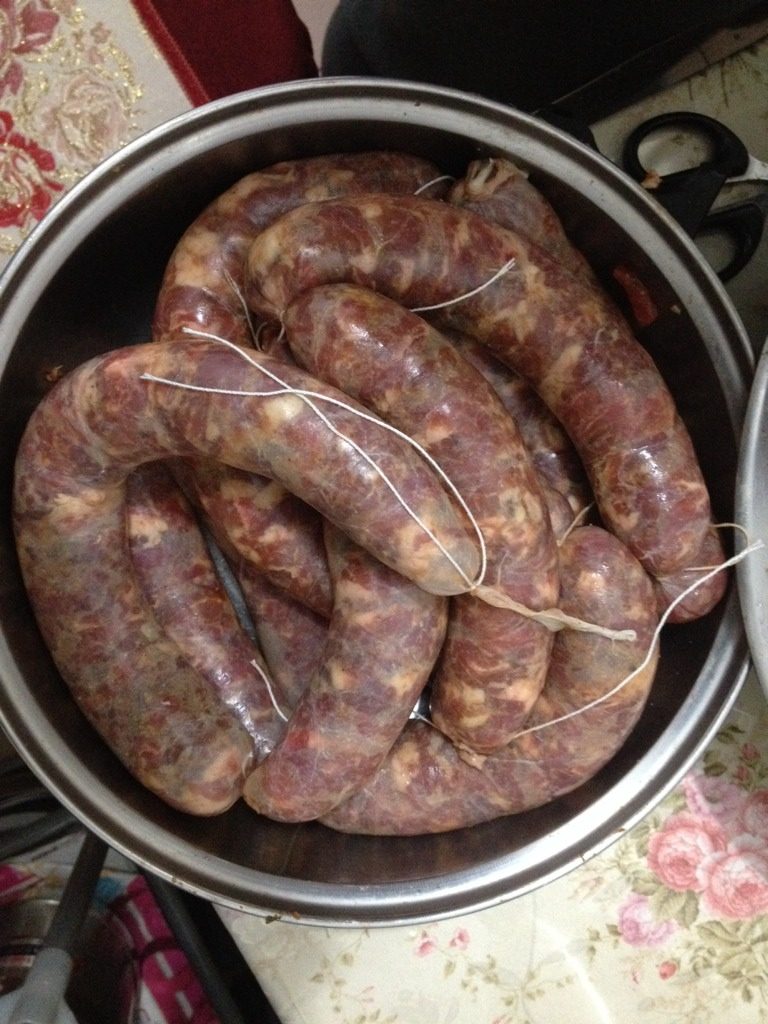 自制香肠,把腌好的肉用漏斗装进肠衣内即可
