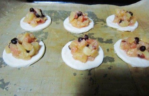 迷你奶酪蜜豆巧克力苹果派,飞饼取出稍微解冻后,用小圆形模具刻出小圆。然后将苹果馅放在小圆饼中。