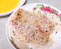 炸猪排,最后放入混合面包粉和黑胡椒粉的盘中,压实