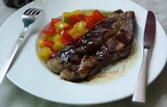 红酒牛扒,将汁淋在煎好的牛扒上,青红彩椒放在牛扒旁边装饰