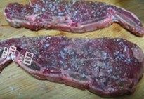 黑椒牛仔骨,牛排放在室温下自然解冻,无需清洗,在牛排的两面都均匀洒上适量的盐和研磨黑胡椒粒