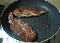 黑椒牛仔骨,锅中放入适量的橄榄油,还可以再放点黄油,放入牛排煎至一面变成金黄色 ,翻面煎另一面,每煎一分钟就翻一次面,共用时间大约4分钟。