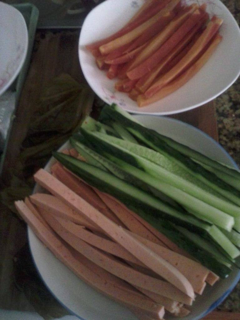 自创清新小寿司,将黄瓜，胡萝卜洗净切条状，火腿肠切条状。