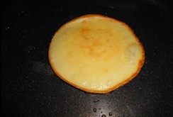 肉桂奶油豆渣饼,平底锅倒入少量油，烧至七成热后转小火，取一大勺面糊倒入中间，摊成圆形面皮，煎至七成熟，中间出现汽泡时翻面，再煎一分钟左右取出。
