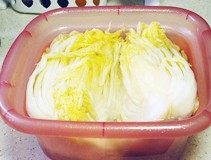 韩国泡菜,腌出水份的白菜用手挤出水份,要尽量挤干净,然后用清水冲洗掉粗粒海盐,把白菜放入矿泉水或凉白开中浸泡投洗