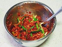 韩国泡菜,将【调味】里的材料放入盆里,加入步骤6的果泥、步骤7的萝卜丝和韭菜段,用手抓匀制成泡菜腌料