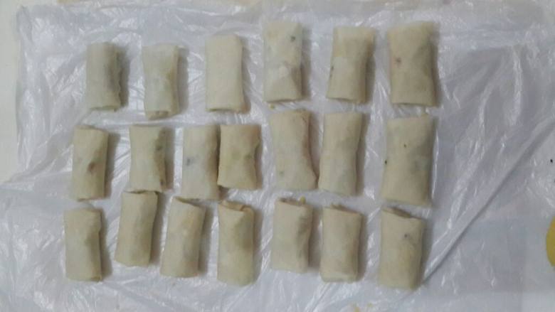潮州春卷,取薄饼皮1.5张（半张作贴底）铺在板上，取馅料30克、猪肉5克放上，包成枕形，接口处用面浆粘合