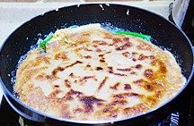 海鲜葱饼,翻面后在饼边儿淋少许油,继续以中小火烙,烙至底面蛋液凝固且金黄即可关火取出