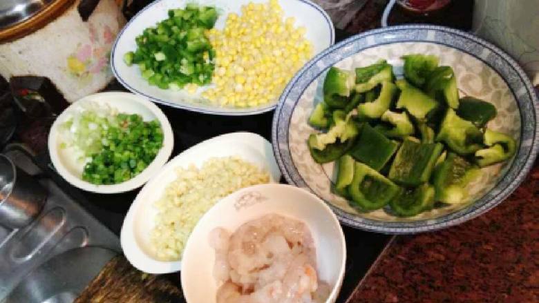 菠萝芝士焗饭,<a style='color:red;display:inline-block;' href='/shicai/ 61'>青椒</a>洗净切粒去籽、<a style='color:red;display:inline-block;' href='/shicai/ 2559'>红萝卜</a>洗净削皮切粒、<a style='color:red;display:inline-block;' href='/shicai/ 500'>玉米</a>瓣粒焯水捞出摊凉。<a style='color:red;display:inline-block;' href='/shicai/ 300'>虾</a>洗净去壳。