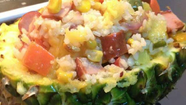 菠萝芝士焗饭,热锅中火，切小块<a style='color:red;display:inline-block;' href='/shicai/ 887'>黄油</a>待融化，加青椒粒、红萝卜粒、玉米粒爆炒后加虾炒，再加饭。最后倒入适量菠萝肉和汁，加少许盐调味。盛入菠萝壳。