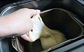 肉松火腿玉米沙拉吐司,揉面时间结束后加入黄油,继续选择和面模式,默认23分钟,能轻易拉出薄膜不断即可