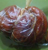 大烧饼夹肘子肉,用大汤勺舀一勺汤放进装肘子的保鲜袋里。将保鲜袋里的空气都排干净,然后封好口。用皮筋系在保鲜袋外面(如图)。