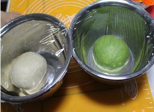 绿茶圈圈土司,分成均匀的2个面团,其中一个面团加抹茶粉揉匀,做成抹茶面团,放入盆中包保鲜膜发酵至2—2.5倍大。