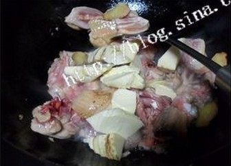 油焖春笋鸡块,热锅凉油,油热后倒入姜片和鸡腿翻炒,鸡腿表面变色后加入笋一起炒。