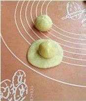 椰蓉开口酥,取一份油皮面团用手掌扁，包入油酥面团，捏紧口。照此完成每个面团。