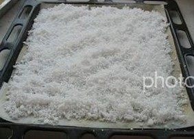 自制椰蓉,挤干水份的椰蓉碎,平铺于烤盘。