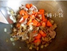 羊肉抓饭,加入胡萝卜块翻炒一下后加入羊肉片拌匀。加盐调味。