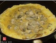 香煎蚝烙,倒入打散的鸡蛋液。轻轻晃动平底锅,使加入的鸡蛋液能均匀地布满整个平底锅。