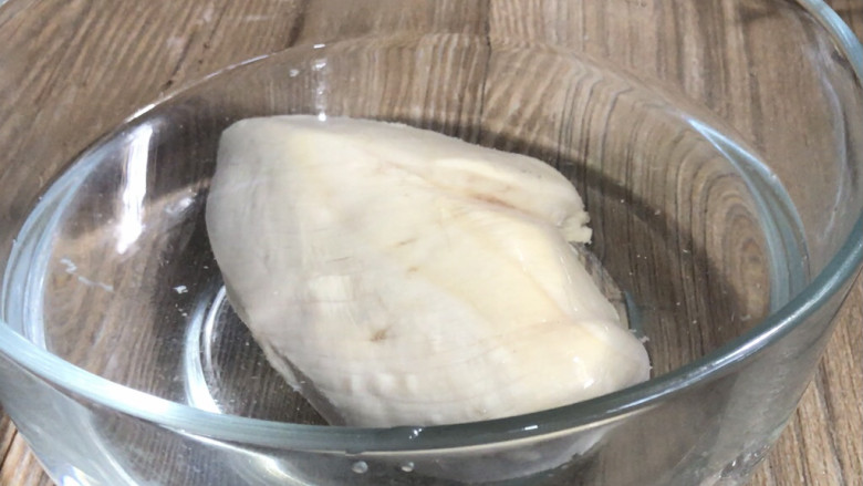 椒麻手撕鸡,把煮好的鸡肉捞出,放入凉开水中浸泡至凉