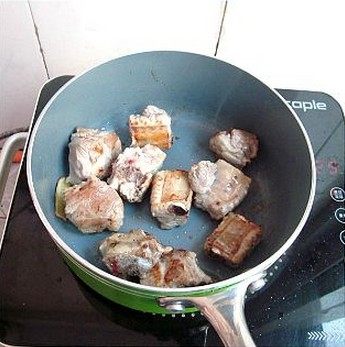 红烧菠萝排骨,炒鍋中倒入1匙油,放入蒜片姜片爆香,再加入排骨,煎至排骨两面金黄。