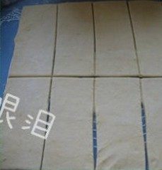 菠萝派,用刮板将面团裁成正方形,再分成相同大小的小长方形若干。