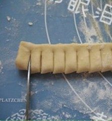 菠萝派,(将铺盖在上方的面片表面撒点面粉,防沾)。对折,用剪子剪出条纹。