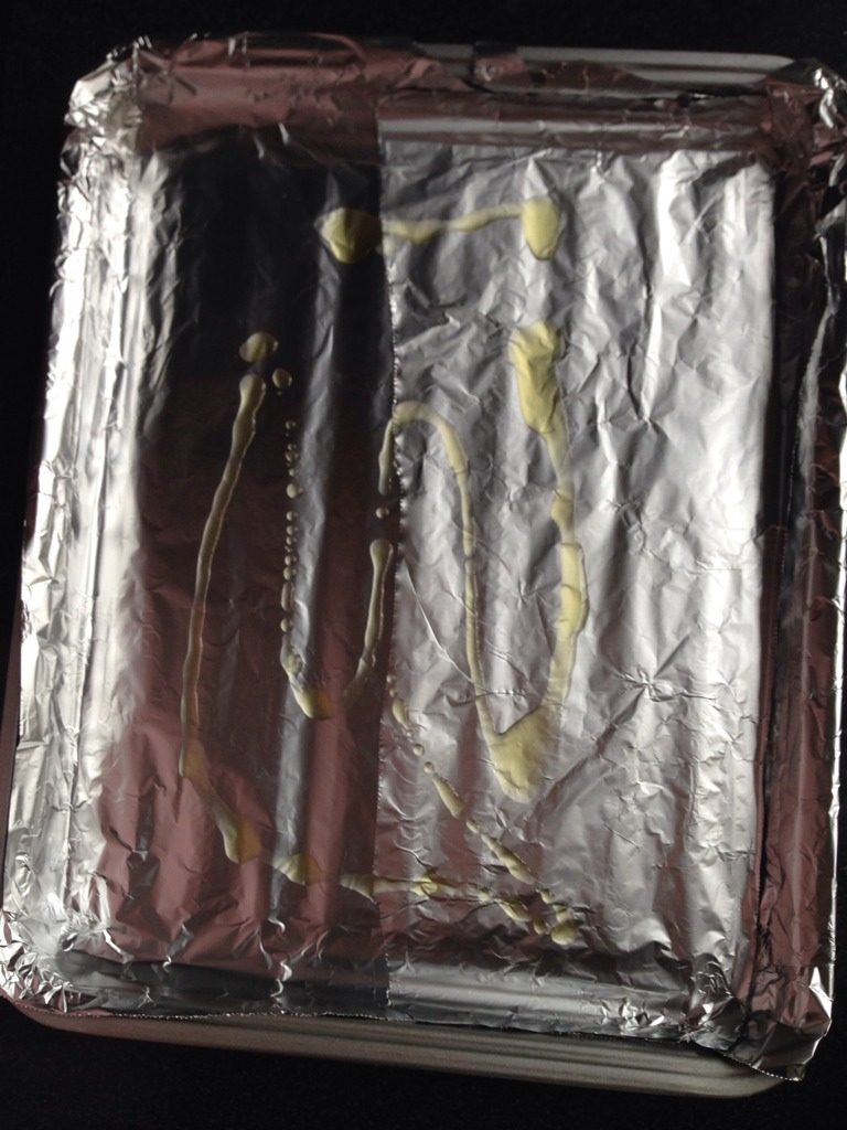 孜然烤土豆片,如图准备烤盘铺上锡纸,并在上面撒少许油,用勺子涂匀,以防土豆烤制时粘盘底