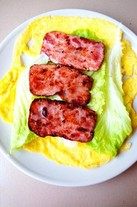 培根鸡蛋卷,将<a style='color:red;display:inline-block;' href='/shicai/ 121'>生菜</a>摆放在蛋皮上，放煎好的培根片卷成卷，上面挤上<a style='color:red;display:inline-block;' href='/shicai/ 699'>番茄酱</a>就OK啦。