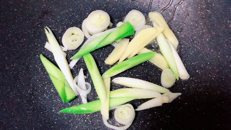虾仁豆腐煲,锅中倒入少许油,放入葱姜、蒜苗爆香。
