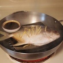 清蒸金鲳鱼,大火烧开水后放入鲳鱼,同时再放一小碟豉油大火同蒸八分钟。