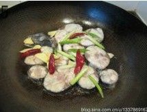 辣烧鲅鱼,放入鲅鱼片慢慢煎制,片刻,将鲅鱼块翻个身,加入葱蒜和干辣椒