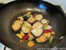 辣烧鲅鱼,下入酱油,轻轻晃动锅子,让每一块鱼肉都均匀上色
